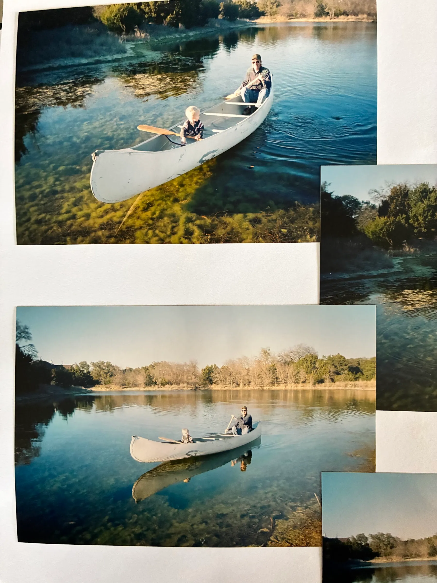 Old snapshots of neighbors canoeing on the pond, laid out on a table.