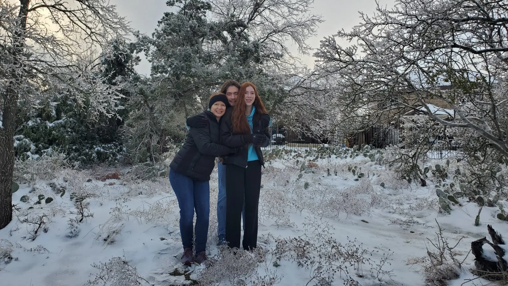A family bundled up on the trail on a snowy winter morning.